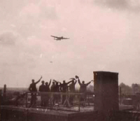 Waving at a Lancaster from a rooftop