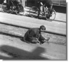 Young Dutch boy steeling the wood block from the tram rails in order to get wood, Photo, national archives of canada